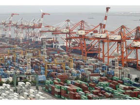 This July 2018, photo shows containers piled up at a Tokyo port. Japan's exports have fallen 8.4 percent in January from a year earlier while imports also edged lower, suggesting a deepening impact from China's economic slowdown. Customs data released Wednesday, Feb. 20, 2019 showed exports to all of Asia dropped 13 percent year-on-year, largely due to a 17 percent decline in shipments to China.
