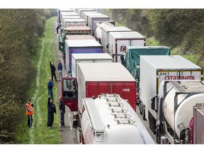 FILE - In this April 6, 2016 file photo, truck drivers stand among trucks on the highway from Brussels to Luxembourg, in Spontin, Belgium. The European Union has reached a tentative agreement on the first specific EU standards for trucks to get polluting CO2 levels down. A Tuesday, Feb. 19, 2019, agreement between negotiators from the European Parliament and member states says that such emissions will have to be 30 percent down by 2030 compared to today's levels.