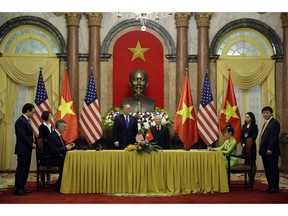 President Donald Trump and Vietnamese President Nguyen Phu Trong watch as VietJet President Nguyen Thi Phuong Thao, right, and Kevin McAllister, CEO of Boeing Commercial Airplanes, left, sign a business agreement at the Presidential Palace, Wednesday, Feb. 27, 2019, in Hanoi.