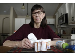 Retired public school teacher Gail Orcutt, of Altoona, Iowa, looks over some of the prescription drugs she takes, Friday, Feb. 15, 2019, in Altoona, Iowa. Orcutt pays $2,600 the first month of the year, and then $750 every other month for a lung cancer medication. With health care a top issue for American voters, Congress may actually be moving toward doing something this year to address the high cost of prescription drugs.