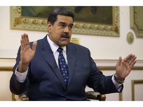 Venezuela's President Nicolas Maduro speaks during an interview with The Associated Press at Miraflores presidential palace in Caracas, Venezuela, Thursday, Feb. 14, 2019. Maduro is inviting a U.S. special envoy to come to Venezuela after revealing during the interview that his foreign minister recently held secret meetings with the U.S. official in New York.