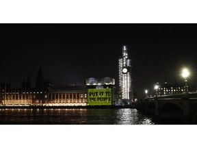 A projection calling for a second referendum or a so-called "Peoples's vote", on behalf of a pressure group, is cast onto the Houses of Parliament in London, Wednesday Feb. 27, 2019.  British Prime Minister Theresa May says she will give British lawmakers a choice of approving her divorce agreement, leaving the EU March 29 without a deal or asking to delay Brexit by up to three months.