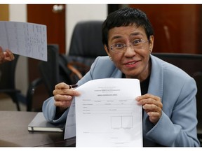 Maria Ressa, the award-winning head of a Philippine online news site Rappler that has aggressively covered President Rodrigo Duterte's policies, shows an arrest form after being arrested by National Bureau of Investigation agents in a libel case Wednesday, Feb. 13, 2019 in Manila, Philippines. Ressa, who was selected by Time magazine as one of its Persons of the Year last year, was arrested over a libel complaint from a businessman which Amnesty International has condemned as "brazenly politically motivated." Duterte's government says the arrest was a normal step in response to the complaint.