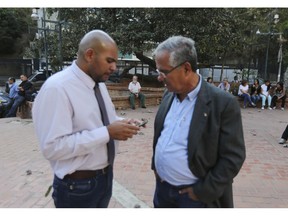In this Feb. 19. 2019 photo, Danny Golindano, left, a volunteer doctor, speaks with his collage Juan Requesens, father jailed lawmaker Juan Requesens, prior a meeting for recruiting volunteers, at a square in Caracas, Venezuela. The citizen brigade is one of the most ambitious undertakings Venezuela's opposition has attempted.