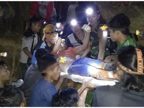 In this undated photo released by Indonesian Search And Rescue Agency (BASARNAS) rescuers evacuate a survivor from a collapsed gold mine in Bolaang Mongondow, North Sulawesi, Indonesia. The collapse of an unlicensed gold mine in Indonesia's North Sulawesi province has buried dozens of people, a disaster official said Wednesday, Feb. 27, 2019, as emergency personnel used their bare hands and farm tools in a desperate attempt to reach victims calling for help from beneath the rubble. (BASARNAS via AP)