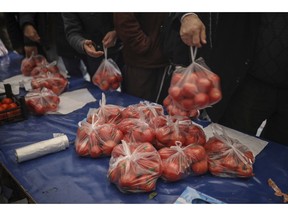 In this Sunday, Feb. 17, 2019 photo, shoppers wait in line to buy tomatoes at a government-run market selling spinach, tomatoes and peppers at discounted prices in an Istanbul neighbourhood. Turkey's President Recep Tayyip Erdogan's government has set up dozens of these temporary stalls in Turkey's largest cities in a bid to mitigate the effects of soaring food prices that have stung households. The move comes just over a month before Erdogan faces local elections on March 31, when runaway prices and an economic downturn could cost his ruling party some key municipal seats.