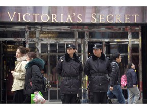 Security officers stand guard outside a store for American lingerie retailer Victoria's Secret at an outdoor shopping street in Beijing, Tuesday, Feb. 26, 2019. American companies in China increasingly worry U.S.-Chinese relations will deteriorate and are "hedging their bets" by delaying investments or moving operations, a business group reported Tuesday.