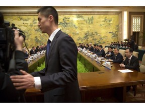 A security official escorts journalists from the opening session of trade negotiations between U.S. and Chinese trade representatives at the Diaoyutai State Guesthouse in Beijing, Thursday, Feb. 14, 2019.