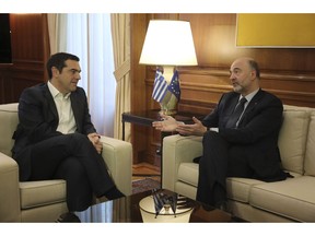 Greek Prime Minister Alexis Tsipras, left, meets with European Commissioner for Economic and Financial Affairs Pierre Moscovici in Athens, on Thursday, Feb. 28, 2019 .