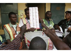 Party agents argue with electoral commission officials on a ballots the claim it was valid for the presidential race after the Gwadabawa polling station closed in Yola, Nigeria, Saturday Feb. 23, 2019. Incumbent President Muhammadu Buhari is facing opposition presidential candidate Atiku Abubakar in the presidential election.