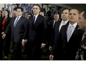 Brazil's President Jair Bolsonaro, center, arrives at the National Congress to deliver a proposal to overhaul Brazil's pension system, in Brasilia, Brazil, Wednesday, Feb. 20, 2019. Lawmakers received this week an anti-crime bill and a proposal to overhaul Brazil's pension system, the government's flagship reform.