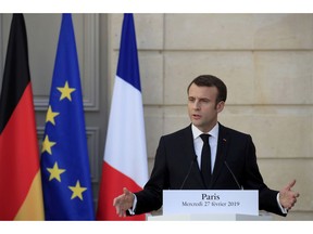 French President Emmanuel Macron attends a press conference with German Chancellor Angela Merkel at the Elysee Palace in Paris, Wednesday, Feb. 27, 2019.