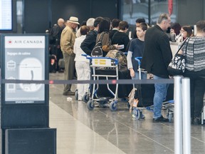Passengers line up at an Air Canada check in desk at Trudeau Airport in Montreal, following Canada's decision to ground all Boeing 737 Max 8 aircraft from departing, arriving or flying over Canadian airspace.