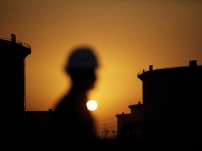 The sun sets over crude oil storage tanks at the Juaymah tank farm, operated by Saudi Aramco, in Ras Tanura, Saudi Arabia.