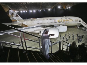 FILE - In this Dec. 18, 2014 file photo, an Emirati man takes a selfie in front of a new Etihad Airways A380 in Abu Dhabi, United Arab Emirates. The Abu Dhabi-based long-haul carrier Etihad Airways said Thursday, March 14, 2019 it lost $1.28 billion in 2018, the third consecutive year of losses of over a billion dollars.