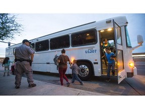 FILE - In this May 28, 2014 file photo, migrants are released from ICE custody at a Greyhound Bus station in Phoenix. Greyhound is no longer allowing immigration authorities to drop off families inside bus stations, forcing them to wait outside until they have a ticket. U.S. Immigration and Customs Enforcement agency confirmed Friday, March 15, 2019, that it had been asked to drop migrants off outside the facility.
