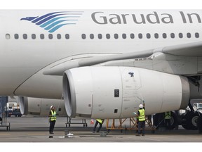 FILE - In this Sept. 28, 2015, file photo, workers clean a jetliner at GMF AeroAsia facility at Soekarno-Hatta International Airport in Jakarta, Indonesia. Indonesia's flag carrier is seeking the cancellation of a multibillion-dollar order for 49 Boeing 737 Max 8 jets, citing a loss of confidence in the model following two crashes in the space of a few months.