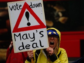 An anti-Brexit supporter shouts slogans during a protest outside the Houses of Parliament in London on Tuesday. Britain's attorney general punctured Prime Minister Theresa May's hopes of winning backing for her Brexit deal.