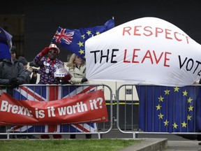 Pro-Brexit leave the European Union supporters and anti-Brexit remain in the European Union supporters take part in a protest outside the Houses of Parliament in London, Tuesday, March 12, 2019.