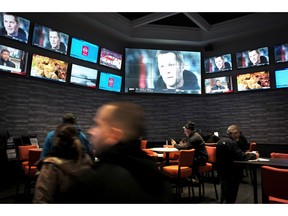 FILE - In this Monday, Jan. 28, 2019 file photo, patrons visit the sports betting area of Twin River Casino in Lincoln, R.I. The state lottery released figures on Friday, March 29, 2019, showing that casinos in Rhode Island lost nearly $900,000 on sports betting in February, after they paid out winning bets for the Super Bowl and other professional sports.