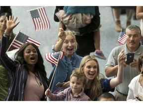 FILE - In this Sept. 20, 2017, file photo, family members react as they welcome their relatives as new U.S. citizens after taking the citizenship oath during naturalization ceremonies at a U.S. Citizenship and Immigration Services (USCIS) ceremony in Los Angeles. A growing number of Americans say immigration should remain the same or be increased since the Trump administration ramped up immigration enforcement. That's according to the General Social Survey, which has also found a growing partisan divide on the topic. The poll shows 34 percent of Americans want immigration to be reduced, down from 41 percent in 2016. It's the first time since the question was asked in 2004 that more Americans want immigration levels to stay the same than to be reduced.