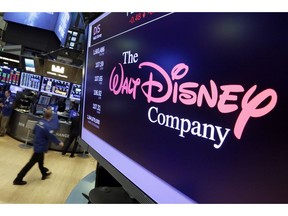 FILE - In this Aug. 8, 2017, file photo, The Walt Disney Co. logo appears on a screen above the floor of the New York Stock Exchange. Disney closed its $71 billion acquisition of Fox's entertainment assets on Wednesday, March 20, 2019, more than a year after the mega merger was proposed. Disney gets far ranging properties ranging from Fox's film studios, including "Avatar" and X-Men, to its TV productions such as "The Simpsons" and networks including National Geographic.