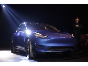 Tesla CEO Elon Musk, right, stands next to the Model Y at Tesla's design studio Thursday, March 14, 2019, in Hawthorne, Calif. The Model Y may be Tesla's most important product yet as it attempts to expand into the mainstream and generate enough cash to repay massive debts that threaten to topple the Palo Alto, Calif., company.