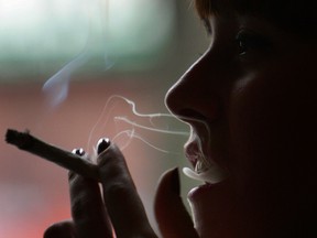 A woman smokes a cigarette of marijuana in an Amsterdam cafe.