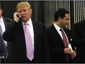 FILE - In this Sept. 14, 2005, file photo, businessman Donald Trump, left, talks on his cellphone with Felix Sater, right, outside after speaking at the Bixpo 2005 business convention at the Budweiser Events Center in Loveland, Colo. Sater, a Soviet emigre who befriended Trump over a series of development deals in the 2000s and pushed the Trump Tower Moscow project before and during the 2016 presidential campaign, has emerged as a key figure in House Democrats' investigations into Trump's Russia connections.