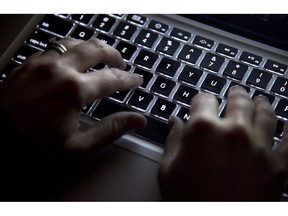 A woman uses her computer keyboard to type while surfing the internet in North Vancouver, B.C., on Wednesday, December, 19, 2012. Authorities in Canada and Australia say police have conducted searches in two cities as part of an investigation of criminal networks that use a type of malicious software to gain unauthorized access to computer systems.