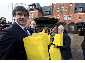 Former regional Catalan President Carles Puigdemont carries yellow bags with books of Catalan authors, as he arrives at the prison in Neumuenster, Germany, March 25, 2019. Carles Puigdemont donates 100 books of Catalan authors in German translation for the prison library, where he was imprisoned a year ago.