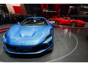 Visitors look at the new 'Ferrari F8 Triturbo' during the press day at the '89th Geneva International Motor Show' in Geneva, Switzerland, Tuesday, March 05, 2019. The 'Geneva International Motor Show' takes place in Switzerland from March 7 until March 17, 2019. Automakers are rolling out new electric and hybrid models at the show as they get ready to meet tougher emissions requirements in Europe - while not forgetting the profitable and popular SUVs and SUV-like crossovers.