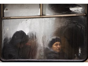 Commuters are seen through the window of a public bus as they travel in central Vinnytsia, Ukraine, Wednesday, March 27, 2019. Presidential elections will be held in Ukraine on March 31.