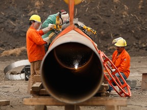 Enbridge workers weld pipe in Manitoba in 2018. Enbridge's Line 3 delay has heightened concerns Alberta may impose cuts for longer than its current target of year-end.