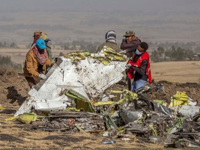 Rescuers work at the scene of an Ethiopian Airlines flight crash near Bishoftu, or Debre Zeit, south of Addis Ababa,  Ethiopia, on Monday. A spokesman says Ethiopian Airlines has grounded all its Boeing 737 Max 8 aircraft as a safety precaution, following the crash of one of its planes in which 157 people were killed.