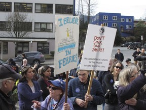 In this photo taken Wednesday March 20, 2019, a group gathered in front of the Alaska Capitol, some carrying signs, in support of the Alaska Marine Highway System in Juneau, Alaska. Gov. Mike Dunleavy's administration has proposed big cuts as it seeks options for reshaping the ferry system, which is an important mode of transport for many coastal communities.