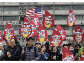 Protesters hold signs during a rally demanding the denuclearization of the Korean Peninsula and peace treaty near the U.S. embassy in Seoul, South Korea, Thursday, March 21, 2019. The Korean Peninsula remains in a technical state of war because the 1950-53 Korean War ended with an armistice, not a peace treaty. More than 20 protesters participated at a rally and also demanding the end the Korean War and to stop the sanction on North Korea. The letters read "Restarting operations at Kaesong industrial complex and Diamond Mountain resort."