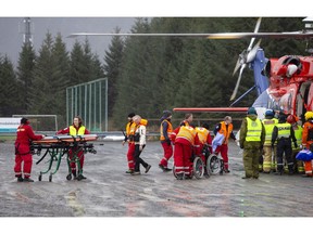 Passengers are helped from a rescue helicopter in Fraena, Norway, Sunday March 24, 2019, after being rescued from the Viking Sky cruise ship. Rescue workers are evacuating more passengers from a cruise ship that had engine problems in bad weather off Norway's western coast while authorities prepare to tow the vessel to a nearby port.