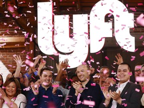 Confetti falls as Lyft CEO Logan Green, centre and President John Zimmer, centre left, ring the Nasdaq opening bell celebrating the company's initial public offering (IPO) on Friday, March 29, 2019 in Los Angeles, California.