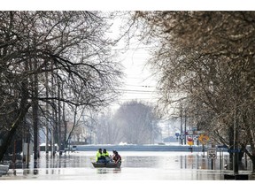 People on a boat float down floodwaters that cover Washington Street Wednesday, March 20, 2019, in Hamburg, Iowa. As some communities along the Missouri River start to shift their focus to flood recovery after a late-winter storm, residents in two Iowa cities are still in crisis mode because their treatment plants have shut down and they lack fresh water.