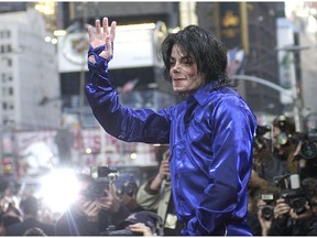 FILE - This Nov. 7, 2001 file photo, Michael Jackson waves to crowds gathered to see him at his first ever in-store appearance in New York. The producers of "The Simpsons" are removing a classic episode that featured the voice of Michael Jackson. Executive producer James L. Brooks told The Wall Street Journal on Thursday, March 7, 2019,  "it feels clearly the only choice to make." He said fellow executive producers Matt Groening and Al Jean are "of one mind on this."