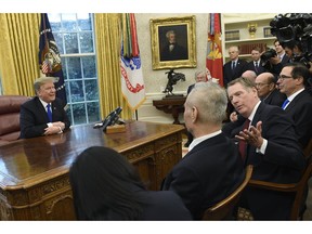 FILE- In this Feb. 22, 2019, file photo President Donald Trump, left, talks at the same time that U.S. Trade Representative Robert Lighthizer, second from right, talks with Chinese Vice Premier Liu He, second from left, during their meeting in the Oval Office of the White House in Washington. The Trump administration and Chinese officials will hold their latest round of talks late this week in Beijing.