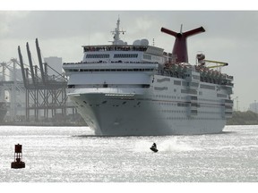 FILE- In this June 20, 2016, file photo, a jet skier passes in front of the Carnival Sensation cruise ship as it leaves PortMiami, in Miami Beach, Fla. On Tuesday, March 26, 2019, Carnival reports financial results.