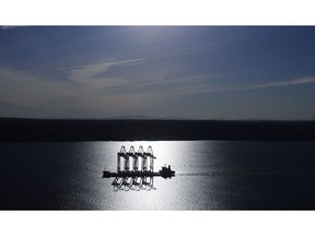 FILE- In this March 5, 2019, file photo the Zhen Hua 31 heavy-lift ship carrying four super-post-Panamax container cranes is silhouetted by the sun as it sails into Commencement Bay in Tacoma, Wash. On Wednesday, March 27, the Commerce Department reports on the U.S. trade gap for January.