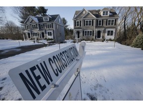 In this Thursday, Feb. 21, 2019 photo a newly constructed homes sit near a sign, in Natick, Mass. On Friday, March 8, the Commerce Department reports on U.S. home construction in January.