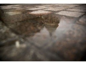 FILE- In this Feb. 22, 2019, file photo the dome of the U.S. Capitol Building is visible in reflection in Washington. On Friday, March 22, the Treasury Department releases federal budget data for February.