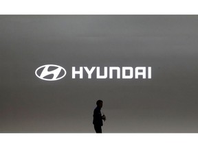 FILE- In this March 28, 2019, file photo a journalist passes by the logo of Hyundai Motor during a media preview of the Seoul Motor Show in Goyang, South Korea. Hyundai has found a new problem that can cause its car engines to fail or catch fire, issuing yet another recall to fix problems that have affected more than 6 million vehicles since 2015.