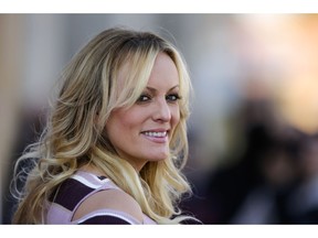 FILE - In this Oct. 11, 2018, file photo, adult film actress Stormy Daniels attends the opening of the adult entertainment fair 'Venus' in Berlin, Germany. Daniels says she's "saddened but not shocked" over the arrest of her former attorney, Michael Avenatti. Daniels issued a statement Monday, March 25, 2019, on Twitter saying she fired Avenatti a month ago after "discovering that he had dealt with me extremely dishonestly." She said she wouldn't elaborate. Avenatti is best known for representing Daniels in lawsuits against President Donald Trump and has been charged with extortion in New York and bank and wire fraud in California.