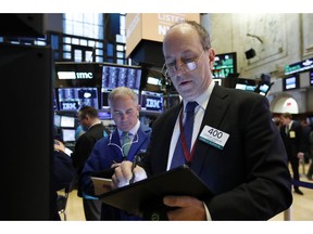 FILE- In this March 18, 2019, file photo trader Gordon Charlop, right, works on the floor of the New York Stock Exchange. The U.S. stock market opens at 9:30 a.m. EDT on Tuesday, March 25.
