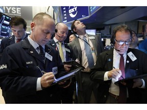 FILE- In this March 13, 2019, file photo traders gather at the post that handles Oaktree Capital Group on the floor of the New York Stock Exchange. The U.S. stock market opens at 9:30 a.m. EDT on Friday, March 22.